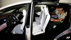 FILE - The Tesla Model X car, with a third row of seats, is introduced at the company's headquarters, Sept. 29, 2015, in Fremont, Calif. 