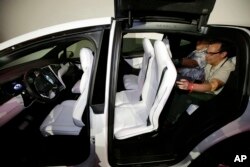 FILE - The Tesla Model X car, with a third row of seats, is introduced at the company's headquarters, Sept. 29, 2015, in Fremont, Calif.