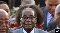 FILE - Zimbabwean president, Robert Mugabe, center, arrives in Pretoria, South Africa, April 7, 2015 for a state visit.