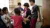 Children gather around Sukaina Mohammed Ali, a top official of the local Mosul government, at an orphanage in Mosul, Iraq. Nearly 60 children are kept in two orphanages in Mosul, Iraq's second largest city, Aug. 19, 2018.