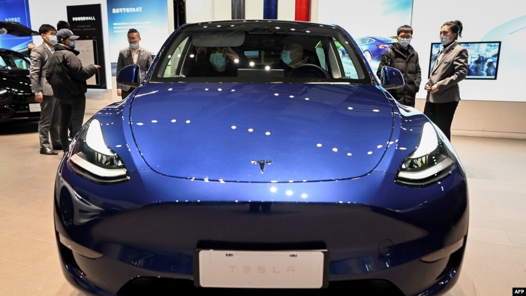 2021年1月5号北京车展上的特斯拉展厅，人们正在观看一辆蓝色特斯拉Y型电动轿车。(photo:VOA)