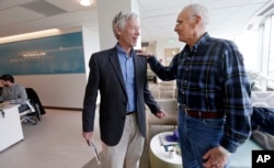 FILE - Dr. David Maloney of the Fred Hutchinson Cancer Research Center is greeted by patient Ken Shefveland, whose lymphoma was successfully treated with CAR-T cell therapy, in Seattle, Washington, March 29, 2017.