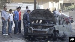 People gather at the scene of a bomb attack in Baghdad, 10 Nov 2010