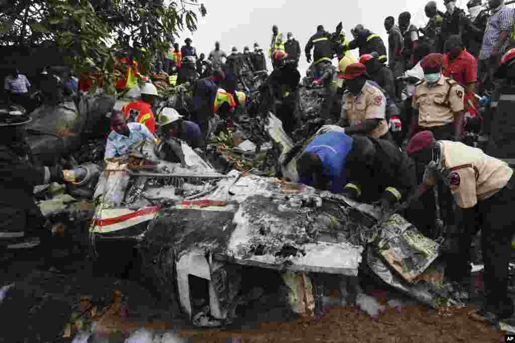 Rescue workers inspect the wreckage of a charter passenger jet that crashed soon after take off from Lagos airport, Nigeria, Oct. 3, 2013.