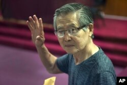 FILE - Former Peruvian President Alberto Fujimori, photographed through a window, attends the final sentencing of his embezzlement trial at a police base on the outskirts of Lima, Jan. 8, 2015.