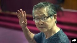 FILE - Former Peruvian President Alberto Fujimori, photographed through a window, attends the final sentencing of his embezzlement trial at a police base on the outskirts of Lima, Jan. 8, 2015.