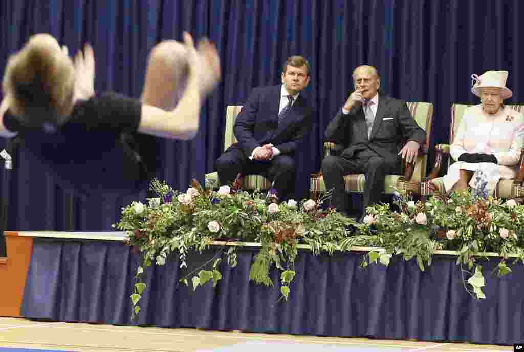 Britain's Queen Elizabeth II and Prince Philip watch a gymnastics display during a visit to Holyport College in England.