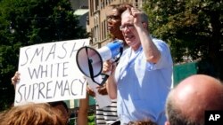 City Advocate Letitia James, left, wait her turn to as City Comptroller Scott Stringer address protesters at a "Peace and Sanity" rally Sunday, Aug. 13, 2017, in the Brooklyn borough of New York, during a rally about white supremacy violence in Charlottesville, Virginia.