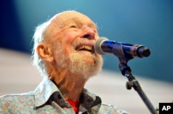 FILE - Pete Seeger performing on stage during the Farm Aid 2013 concert at Saratoga Performing Arts Center in Saratoga Springs, N.Y.