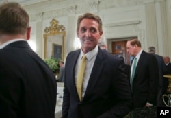 FILE - Sen. Jeff Flake, R-Ariz., center, walks to his seat as he attends a luncheon with other GOP senators and President Donald Trump, July 19, 2017, in the State Dinning Room of the White House in Washington.