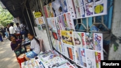 A girl selling weekly journals waits for customers in Rangoon, Burma, April 2, 2012. 