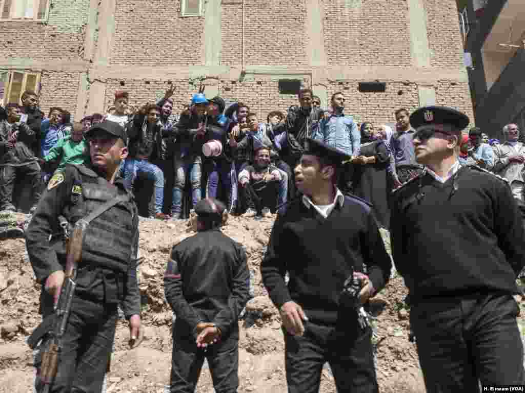 Policemen guard the site, while residents are celebrating the discovery.