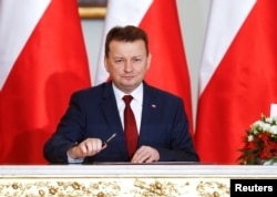 FILE - Polish Defense Minister Mariusz Blaszczak attends a government swearing-in ceremony at the Presidential Palace in Warsaw, Poland, Jan. 9, 2018.