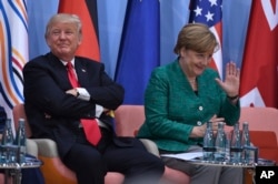 U.S. President Donald Trump, left, and German Chancellor Angela Merkel are seen at the panel discussion of the Women's Entrepreneur Finance event on the second day of the G-20 summit in Hamburg, Germany, July 8, 2017.