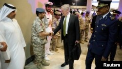 FILE - U.S. Defense Secretary James Mattis, center, is greeted by military dignitaries as he arrives at Al-Udeid Air Base in Doha, Qatar, April 21, 2017.
