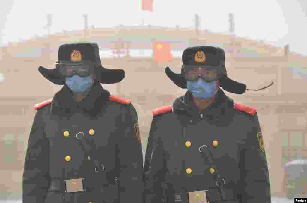 Dua tentara China dengan mengenakan masker - untuk melindungi dari badai pasir -- siaga di Xilin, kawasan otonomi Mongolia Dalam.