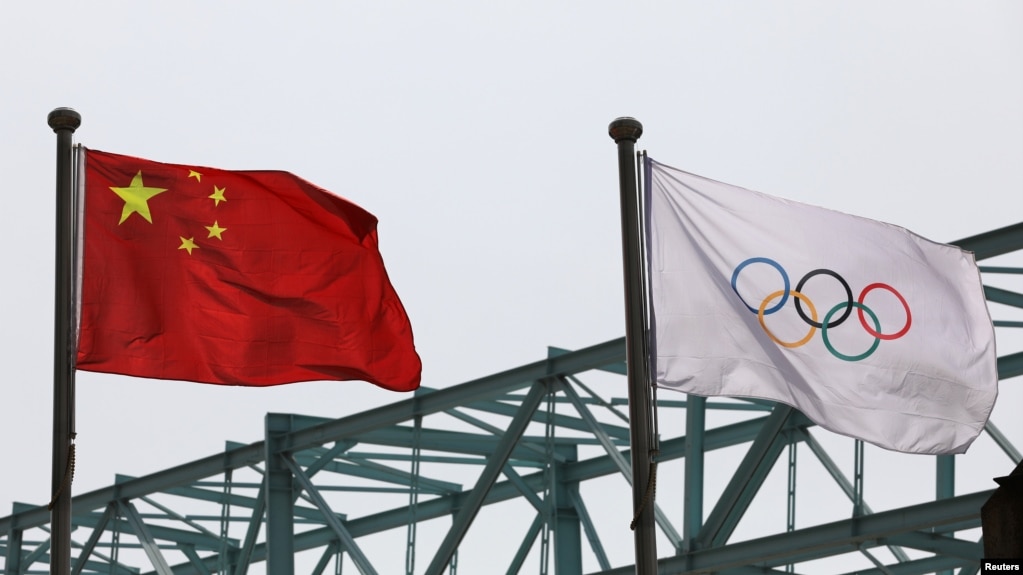 中国国旗和奥运旗帜在北京冬奥组委会外飘扬。（2021年3月30日）(photo:VOA)