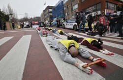 South Korean Buddhist monks and Myanmar nationals living in South Korea march and bow during a protest against Myanmar's military coup in front of the Myanmar embassy in Seoul.