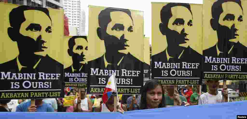 Protesters display placards with images of national hero Apolinario Mabini as they march to the Chinese consulate office in Manila, June 12, 2014.
