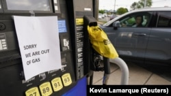 美国燃油管道运输公司Colonial Pipeline遭受网络袭击后，一名维吉尼亚州的司机看着加油站贴在加油泵上的一张燃油售罄的告示。（ 2021年5月12日）