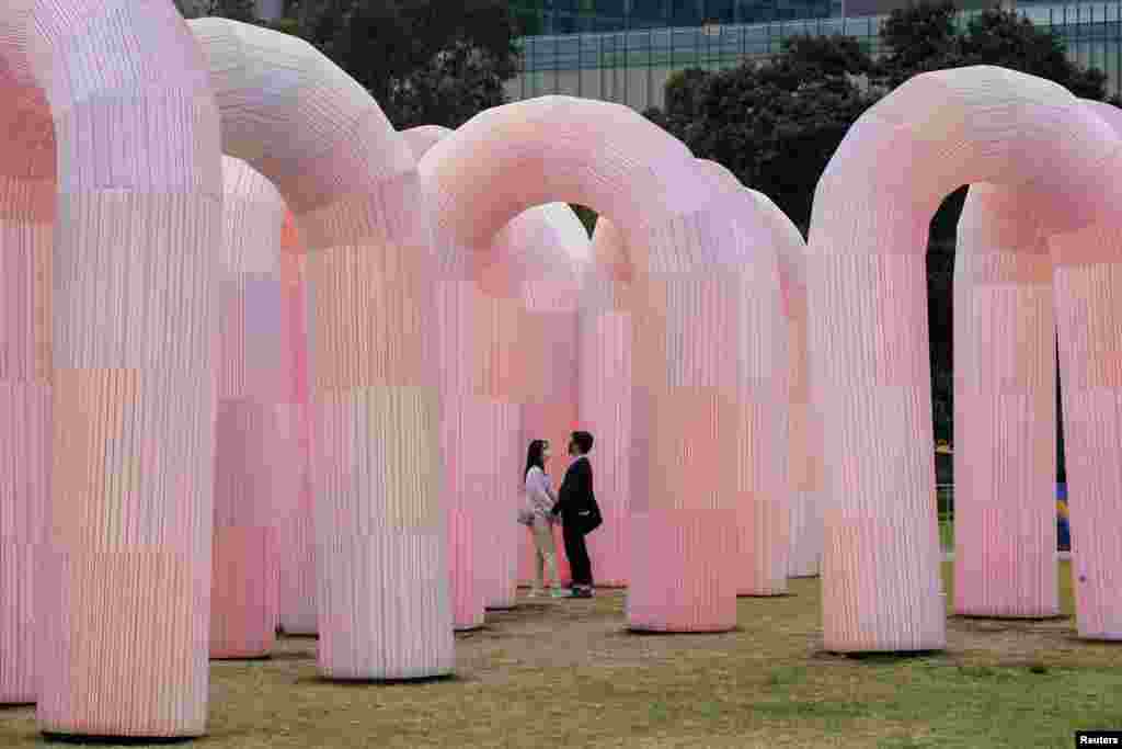People walk through an interactive art installation in a city center park in Sydney, Australia.
