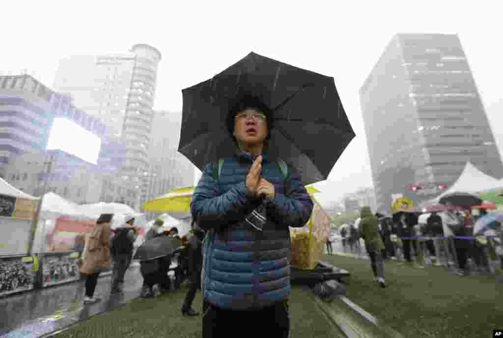 A mourner prays for the victims of the sunken ferry Sewol outside a temporary memorial altar in Seoul, April 16, 2015.