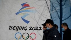 People walk past the Beijing 2022 Winter Olympics logo at the Shougang Park in Beijing on Dec. 1, 2021.