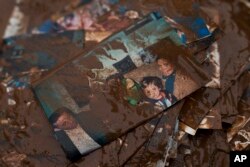 Family pictures are covered with mud after flood water has receded outside a house in the town of Mandra, Greece, Nov. 16, 2017.