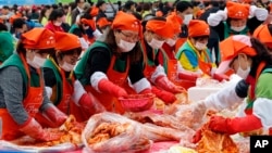 Những người Hàn Quốc và khách du lịch làm kimchi để quyên góp cho các nước láng giềng nghèo trong lễ hội kimchi ở Seoul, Hàn Quốc, thứ Sáu ngày 6/11/2015.