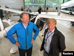 Norwegian Transport Minister Ketil Solvik-Olsen and head of the Avinor Dag Falk-Petersen stand next to a two-seat electric plane made by Slovenian company Pipistrel at Oslo Airport, Norway, June 18, 2018.
