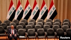 FILE - Iraqi Prime Minister Haider al-Abadi sits during a parliamentary session to vote on Iraq's new government at the parliament headquarters in Baghdad, Sep. 8, 2014. Negotiations between the country’s highly polarized political factions have failed to produce a way forward for Iraq.