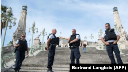 Cuatro policías montan guardia en una gran escalinata de acceso a la estación de tren de Saint-Charles, este domingo 1 de octubre en la ciudad francesa de Marsella.