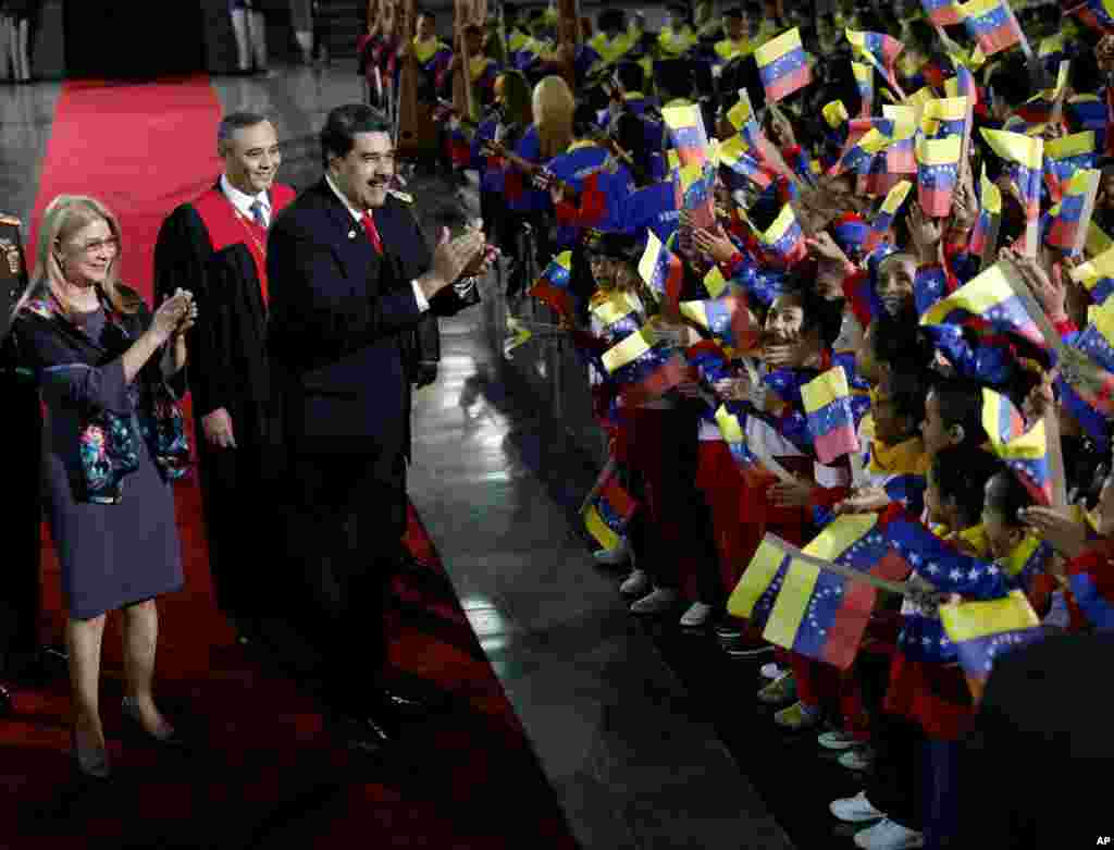 Venezuela&#39;s President Nicolas Maduro and first lady Cilia Flores stop to greet flag-waving children upon arrival to the Supreme Court for Maduro&#39;s inauguration ceremony in Caracas.