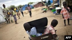 Children play with a suitcase in a IDP camp for the Nuer ethnic group inside the UNMISS compound in Bor, South Sudan, on February 27, 2014.