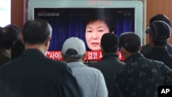 ພວກເດີນທາງ ຢູ່ສະຖານີລົດໄຟ ໃນນະຄອນຫຼວງໂຊລ ຢຸດເບິ່ງຂ່າວ ການກ່າວຄຳປາໄສ ຂອງ ປະທານາທິບໍດີ Park Geun-hye. (ວັນທີ 4 ພະຈິກ 2016)