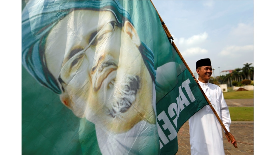 Seorang pemuda muslim memegang bendera bergambar Rizieq Shihab, Jakarta, 2 Desember 2019. (Foto: REUTERS/Willy Kurniawan)