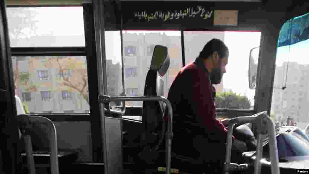 Bus driver Adel Abd El Fatah sits inside a damaged bus after a bomb blast near the Al-Azhar University campus in Cairo&#39;s Nasr City district, Dec. 26, 2013. 