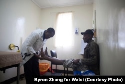 An occupational therapist at The Plaster House examines a patient in Tanzania.