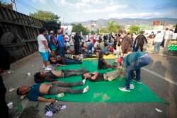 Injured migrants are cared for on the side of the road next to the overturned truck in which they were traveling near Tuxtla Gutierrez, Chiapas state, Mexico, Dec. 9, 2021.