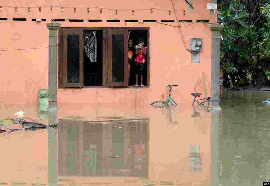 Warga Sri Lanka melongok lewat jendela, sementara rumahnya tergenang banjir di kota Matugama, selatan ibukota Kolombo.