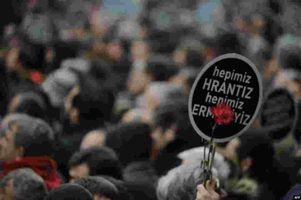 A person holds a banner that reads "We are all Hrant, we are all Armenian" as some tens of thousands of protesters march to mark the fifth anniversary of Turkish-Armenian journalist Hrant Dink's murder in Istanbul, Turkey, Thursday, Jan. 19, 2012 as outra