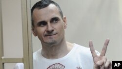 Ukrainian filmmaker Oleh Sentsov gestures as the verdict is delivered at his trial in Rostov-on-Don, Russia, Aug. 25, 2015.