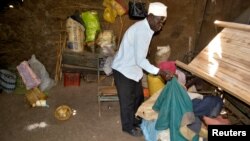 Tito Onyango picks up clothes at the scene where his daughter Mary Atieno was killed after a suspected member of Somali Islamist group al Shabab detonated an explosive device at Kamloma village in Nyakach, Kisumu County, Kenya, Dec. 8, 2021.