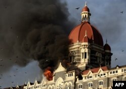 FILE - Flames gush out of The Taj Mahal Hotel in Mumbai, Nov. 27, 2008.