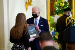 President Joe Biden presents the Medal of Honor to Army Sgt. 1st Class Christopher Celiz for his actions in Afghanistan on July 12, 2018, as his widow Katherine Celiz and daughter Shannon Celiz accept the posthumous recognition during an event in the East Room of the White House, Dec. 16, 2021.