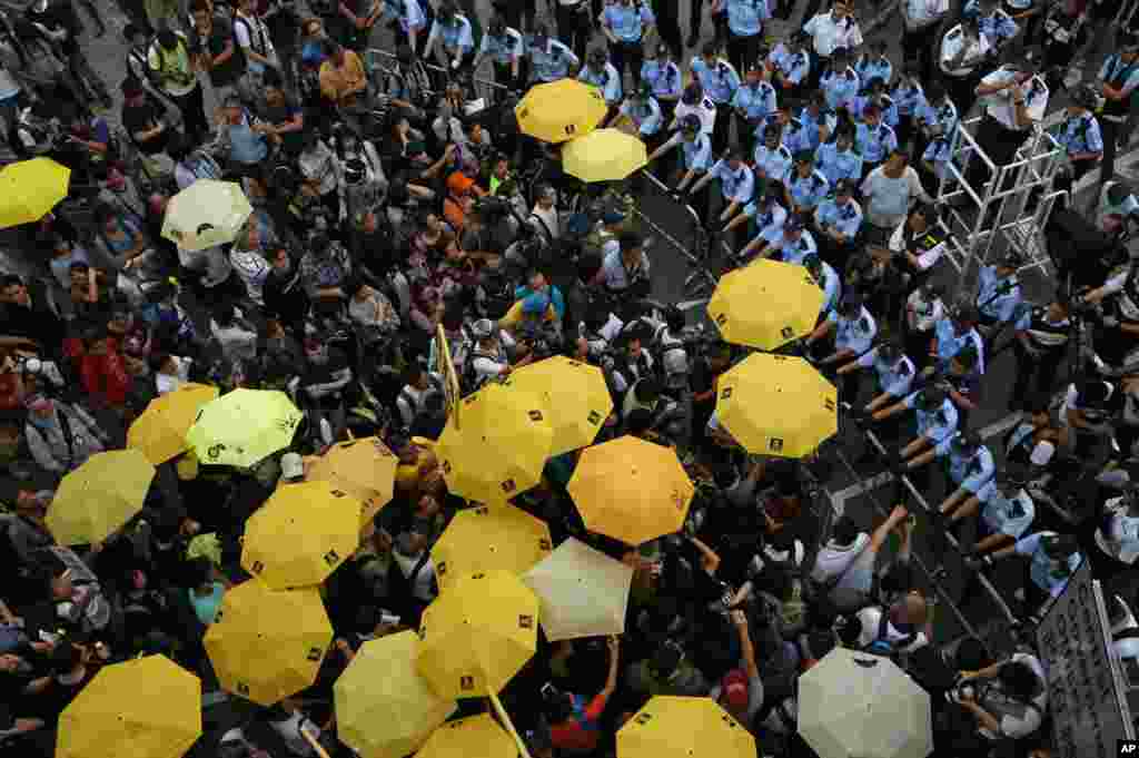 Protesters holding yellow umbrellas gather to observe a moment of silence to mark the first anniversary of the &quot;Umbrella Movement&quot; outside the government headquarters in Hong Kong. A year ago, Hong Kong&#39;s famously busy streets were shut down by pro-democracy activists who occupied them for 79 days.