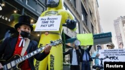 Members of the Patriotic Millionaires hold a federal tax filing day protest outside the apartment of Amazon founder Jeff Bezos, to demand he pay his fair share of taxes, in New York City, U.S., May 17, 2021. REUTERS/Brendan McDermid TPX IMAGES OF THE