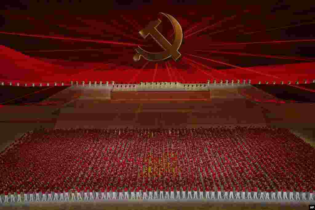 Para penampil dalam pertunjukan berbaris di depan lambang Partai Komunis pada sebuah pertunjukan gala menjelang peringatan 100 tahun berdirinya Partai Komunis China di Beijing hari Senin, 28 Juni 2021. (Foto: AP)