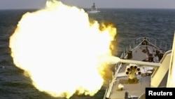 A Chinese navy vessel fires its cannon during the Joint Sea naval drill.