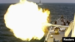 FILE - A Chinese navy vessel fires its cannon during joint exercises with the Russian navy in the East China Sea, May 24, 2014.
